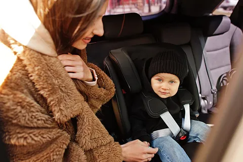 Niño en el coche en su sillita